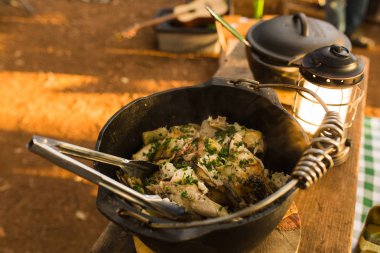 Makarna ve dökme demir içinde hazırlanan yemek kamp tavuk