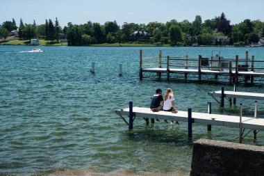 Dock, tekneler ve insanlar ile popüler turistik göl güneşli öğleden sonra