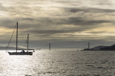 Bir teknede su Marnixkade San Francisco Körfezi üzerinden bir bulutlu gün batımı. Şehrin manzaralarını ve golden gate köprüsü