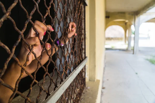 Woman\'s hands gripping bars in abandoned military base structures on Angel Island