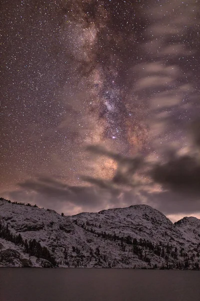Night sky stars over Banner Peak above Garnet Lake in the Ansel Adams wilderness after a fresh snow
