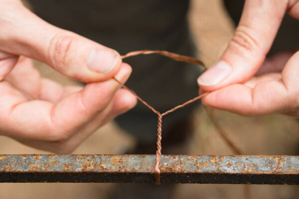 Женщина скручивает жилы в плетеную веревку во время урока выживания.
