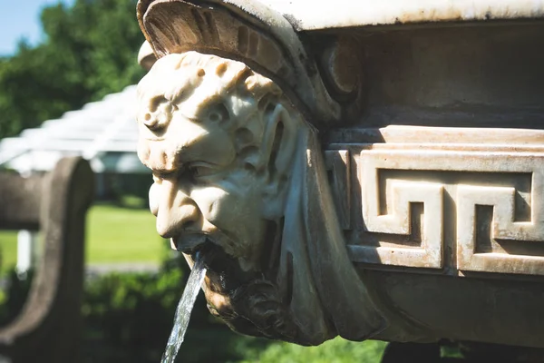 Stone sculpture in garden around a Victorian mansion