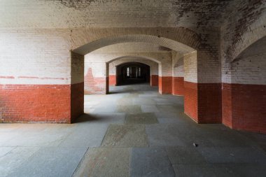 Duvar uzak karanlığa doğru uzanan koridor kemerli. Tipik bir kale ve Victoria dönemi cezaevlerinde