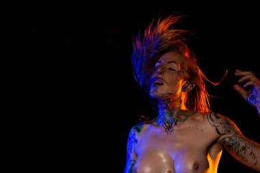 Dövmeli kafkas kadın kaslı ve yağlı cilt pozlar renkli ışıklar altında