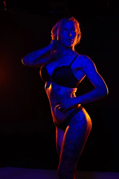 Donna Caucasica Muscolosa Con Tatuaggi Pelle Oliata Posa Sotto Luci — Foto Stock