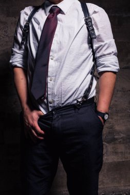 Genç travesti adam yarı resmi giyim bir esaret stil deri koşum takımı ile bir grungy kentsel konumda teşkil etmektedir.