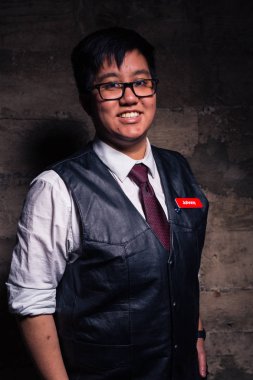 Genç travesti adam yarı resmi giyim bir esaret stil deri yelek ile bir grungy kentsel konumda teşkil etmektedir.