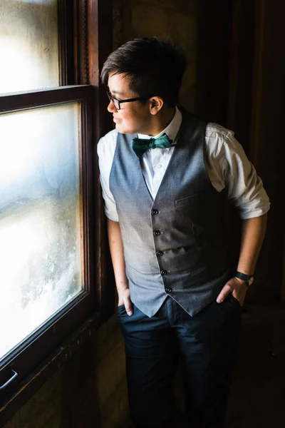 Young transgender man in formal clothing poses in a grungy urban location