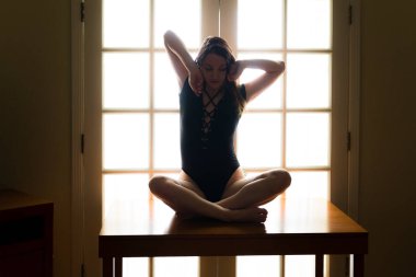 Orta yaşlı beyaz kadın bir tabloda ise arkadan aydınlatmalı siyah tek parça streç giysi teşkil etmektedir