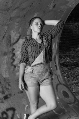 Genç karışık yarış açık havada grungy hipster tarzında pozlar ile renkli ışıklar bir endüstriyel alanda giyimli kadın