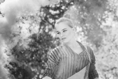 Genç karışık yarış kadın açık havada grungy hipster tarzında pozlar sis bombası ile giyinmiş.