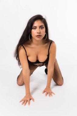 Genç siyah iki parça, file çorap, İspanyol kadın yerleştirmek ve yüksek topuklu ayakkabılar beyaz bir arka plan üzerinde pozlar