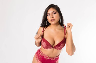 Genç kırmızı iki parça, jartiyer kemer ve yüksek topuklu pozlar İspanyol kadın beyaz bir arka plan üzerine yerleştirmek.