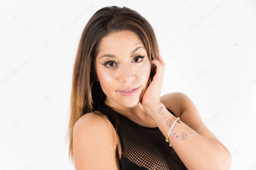 Young fit hispanic woman in black two piece and black high heels posing on a white background