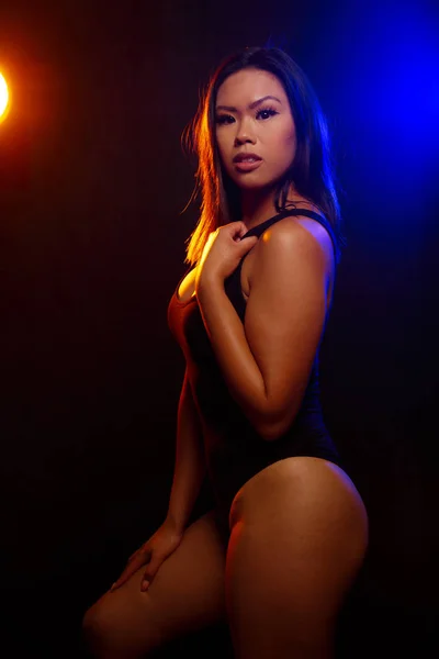 Vältränad Ung Asiatisk Kvinna Svart Bit Poser Mot Svart Orange — Stockfoto