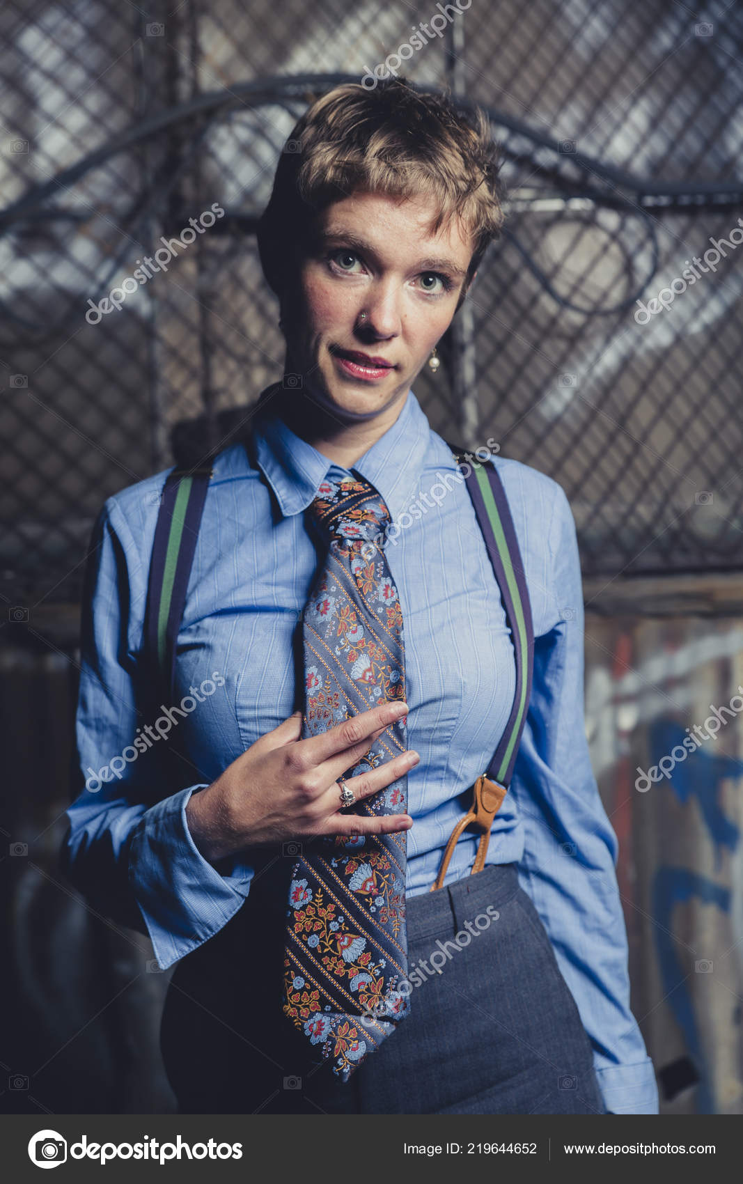 Queer Woman Dressed Suit Tie Poses Grungy Industrial Location Stock Photo by ©Geartooth 219644652