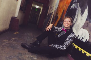 Gömlek ve kravat kadar düğme queer kadın renkli bir koridorda pozlar