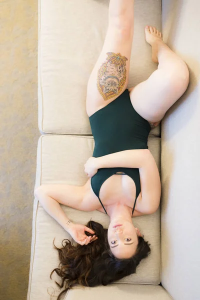 Junge Kaukasische Frau Mit Grünem Trikot Liegt Auf Der Couch — Stockfoto