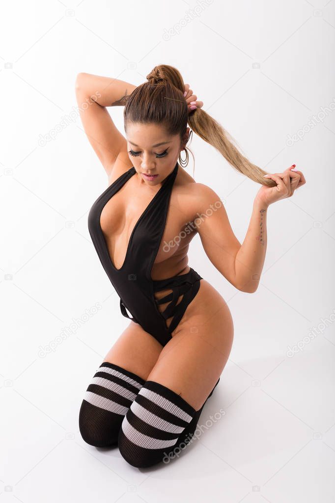 Young fit hispanic woman in black one piece and long striped soc