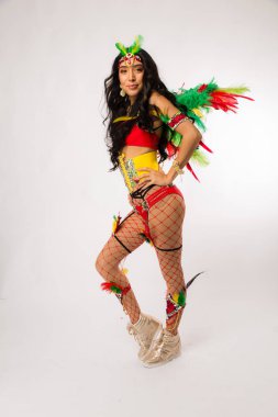 Sıska genç koyu saçlı Latin asıllı kadın Carnaval kostüm ve spor ayakkabıları temiz beyaz arka plan üzerinde poz