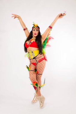 Koyu saçlı Latin asıllı kadın Carnaval kostüm ve spor ayakkabıları temiz beyaz arka plan üzerinde poz