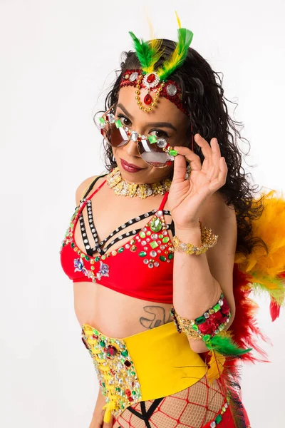 Fit young hispanic woman in Carnaval costume and athletic shoes posing on clean white background