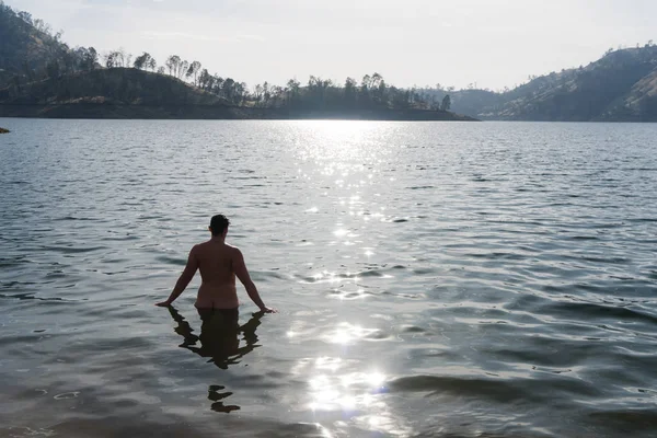 孤独な短い髪の女性は 曇った日に視聴者に背中を持って湖で入浴 — ストック写真
