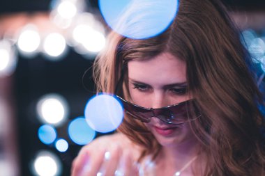 Çekici genç kafkas kadın ağır bokeh ışıklarla dize ile poz veriyor