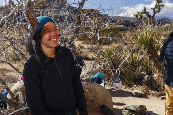 Mixed race female gay rock climber wearing cold weather gear climbing in Southern California