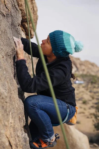 Mixed race woman rock climbs in the desert