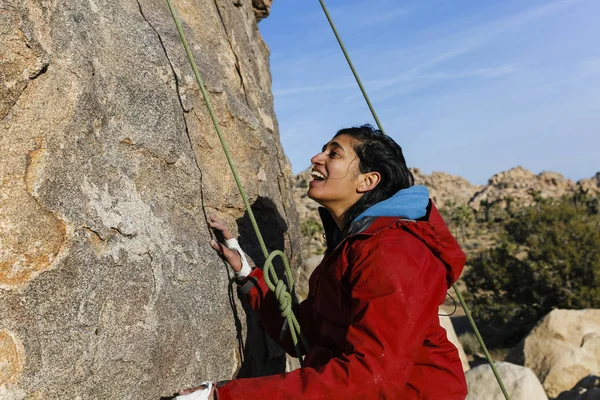 South Asian woman rock climbs in the desert