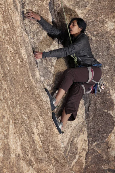 Southeast asian woman rock climbs in the California desert