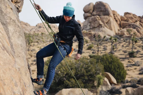 Mixed race woman rock climbs in the desert