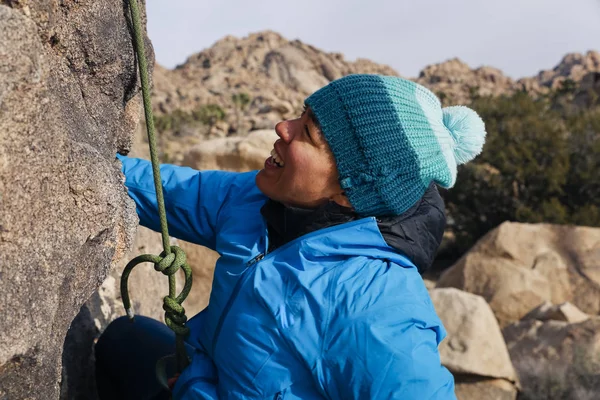 Mixed race woman rock climbs in the desert
