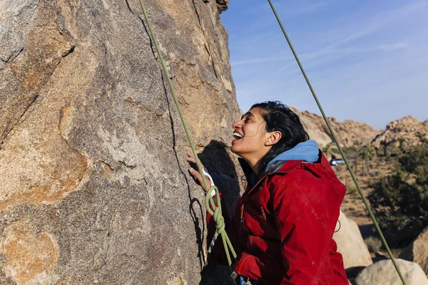 South Asian woman rock climbs in the desert