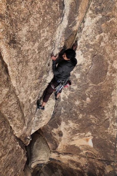 Southeast asian woman rock climbs in the California desert