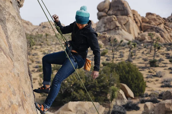 Mixed race woman rock climbs in the desert