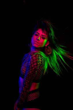 Bangs ve renkli saç ile alternatif model pembe altında pozlar, mavi, ve yeşil ışık bir file üst giyiyor