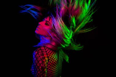 Bangs ve renkli saç ile alternatif model pembe altında pozlar, mavi, ve yeşil ışık bir file üst giyiyor