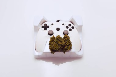 Cannabis flower and game controller on white background clipart