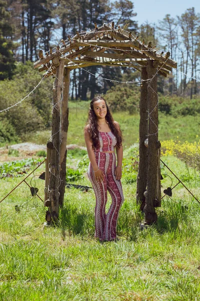 Mischlingsjunge Frau steht unter einem rustikalen Torbogen auf einem Bauernhof — Stockfoto