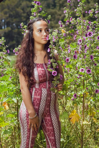 Смешанная раса молодая женщина стоит среди высоких цветов снаружи — стоковое фото