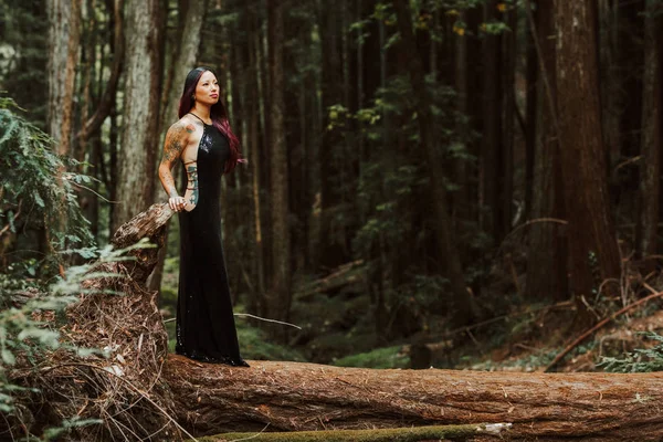 Asiático tatuado mujer en negro vestido de noche poses en un caído re — Foto de Stock