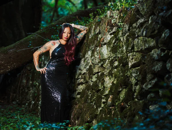 Asiático tatuado mujer en negro vestido de noche poses en un abandone — Foto de Stock