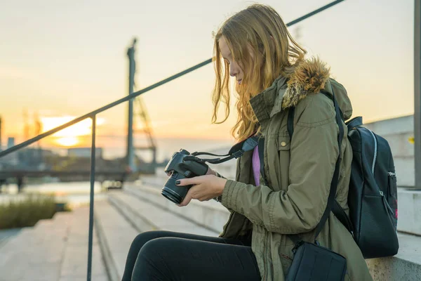 Genç kadın kamera ekranında resim önizlemeleri kontrol ediyor