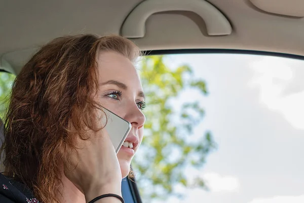 Young woman drives her car and makes a phone call — 스톡 사진