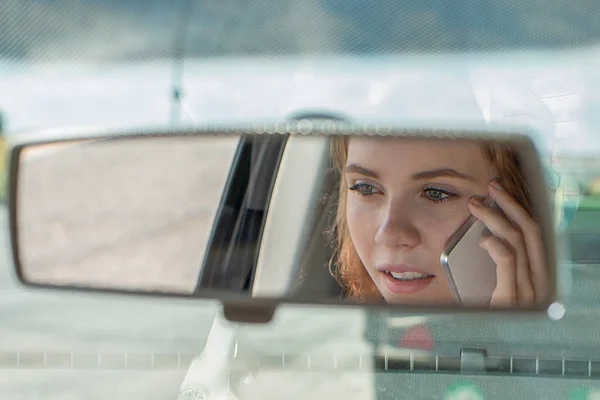 Молодая женщина водит машину и разговаривает по телефону — стоковое фото