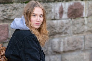 Gülümseyen ve kameraya bakan genç bir kadının portresi