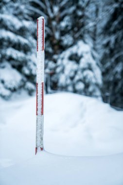 Measuring the snow depth with ruler in the winter clipart